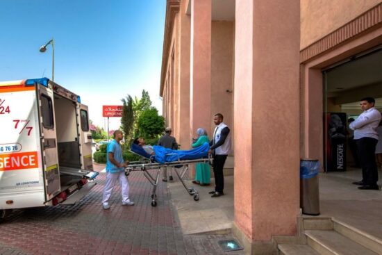 Two paramedics carrying a patient to an ambulance