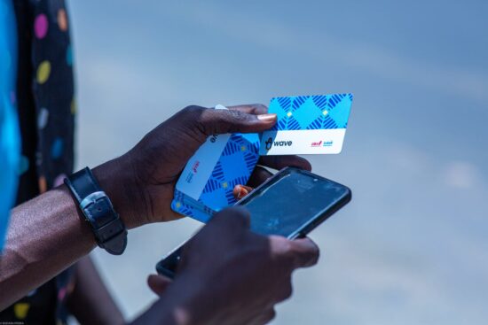 person holding a mobile phone and cards