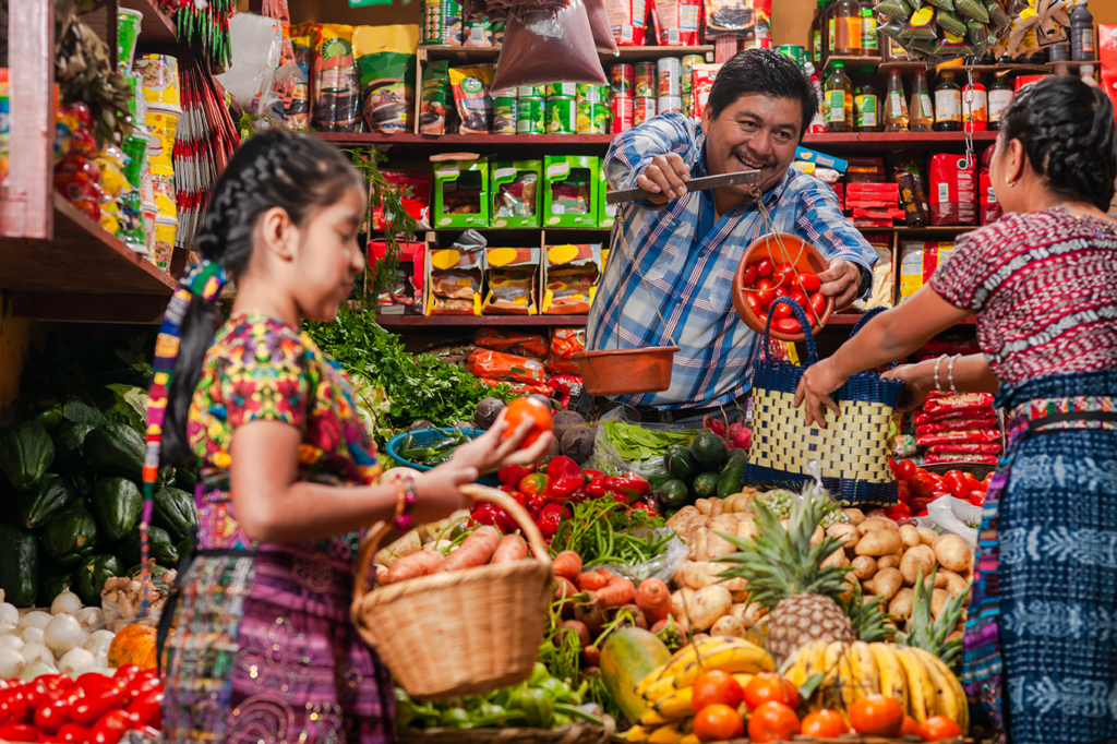 Two persons buying fruit from a small shop in Guatemala