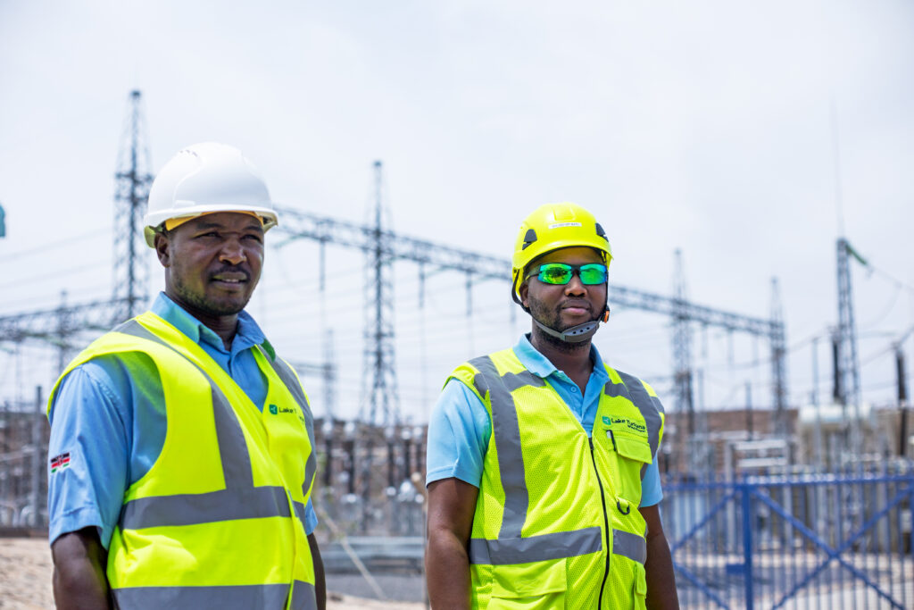 Two people standing outside in a power plant
